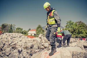 An emergency support officer standing on rubble